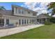 Backyard featuring patio with seating, manicured lawn, and view of the lake at 641 Virginia Dr, Winter Park, FL 32789