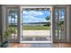 Waterfront view of the backyard from inside the house with patio and beautiful landscaping at 641 Virginia Dr, Winter Park, FL 32789