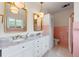 Bright bathroom with dual sinks, marble counters, vintage-style fixtures, and decorative pink tiling at 641 Virginia Dr, Winter Park, FL 32789