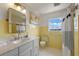 Bright bathroom with a marble countertop vanity, yellow tiling, and stylish mirror at 641 Virginia Dr, Winter Park, FL 32789