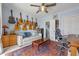Comfortable bedroom with acoustic guitars hanging on the wall, a ceiling fan, and a cozy seating area at 641 Virginia Dr, Winter Park, FL 32789