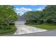 Home exterior featuring a well-manicured lawn, mature trees, and a two-car garage at 641 Virginia Dr, Winter Park, FL 32789