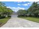 Home exterior featuring a well-manicured lawn, mature trees, and a two-car garage at 641 Virginia Dr, Winter Park, FL 32789