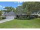 Charming single-story home with lush landscaping, mature trees, and a two-car garage at 641 Virginia Dr, Winter Park, FL 32789