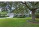 Home exterior featuring a well-manicured lawn, mature trees, and a brick facade at 641 Virginia Dr, Winter Park, FL 32789