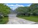 Home exterior featuring a well-manicured lawn, mature trees, and a two-car garage at 641 Virginia Dr, Winter Park, FL 32789
