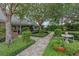 Beautifully landscaped front yard with mature trees, manicured shrubs, and a charming walkway leading to the entrance at 641 Virginia Dr, Winter Park, FL 32789