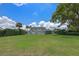 Expansive lush green lawn with lounge chairs, tall hedges, and partial home view at 641 Virginia Dr, Winter Park, FL 32789