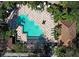 An aerial view of the community pool, surrounded by lounge chairs, lush landscaping, and tiled walkways at 6931 Sperone St, Orlando, FL 32819