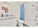 Bathroom with gray floors, white vanity, blue shower curtain, and combination shower and tub at 6931 Sperone St, Orlando, FL 32819