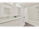 The bathroom features double sinks, quartz counters, white vanity and white tile shower at 6931 Sperone St, Orlando, FL 32819