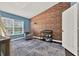 room with brick accent wall, blue paint, gray rocking chair and changing table at 6931 Sperone St, Orlando, FL 32819