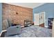 This room features exposed brick, blue accent wall, and gray swivel chair with teddy bear at 6931 Sperone St, Orlando, FL 32819