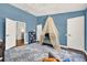 room with crib and blue accent wall, and patterned area rug and dark wood floors at 6931 Sperone St, Orlando, FL 32819