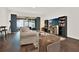 Modern open concept living room featuring a large screen TV, bookshelves, and hardwood flooring throughout at 6931 Sperone St, Orlando, FL 32819