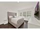 Bright main bedroom featuring a large bed, hardwood floors, and windows offering plenty of natural light at 6931 Sperone St, Orlando, FL 32819
