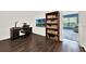 Office with desk, shelves, dark hardwood floors and an adjacent colorful room at 6931 Sperone St, Orlando, FL 32819