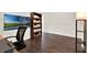 Office with dark hardwood flooring, floor lamp, bookcase, and picture-frame television at 6931 Sperone St, Orlando, FL 32819