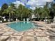Community pool with clear blue water, surrounded by palm trees and lounge chairs at 6931 Sperone St, Orlando, FL 32819