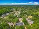 An aerial view showcases this house in a serene neighborhood filled with mature trees and a nearby lake at 704 Forest View Ct, Winter Springs, FL 32708