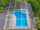 An aerial view highlights the screened-in pool of the home within a lush landscape at 704 Forest View Ct, Winter Springs, FL 32708