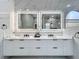 Modern bathroom boasts double vanity with illuminated mirrors, marble countertop, and sleek black hardware at 704 Forest View Ct, Winter Springs, FL 32708