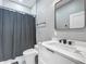 This bathroom has a shower with a gray curtain, a sink with a mirror, and white cabinets at 704 Forest View Ct, Winter Springs, FL 32708