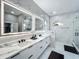 Modern bathroom features double sinks, lighted mirrors, marble countertops, and glass-enclosed shower at 704 Forest View Ct, Winter Springs, FL 32708