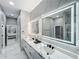 Stylish bathroom features double vanity, illuminated mirrors, and marble countertops with sleek black hardware at 704 Forest View Ct, Winter Springs, FL 32708