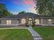 This well-maintained home boasts a manicured lawn and a walkway leading to the arched front door at 704 Forest View Ct, Winter Springs, FL 32708