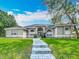 Charming single-story home featuring a beautifully landscaped front yard with manicured lawn at 704 Forest View Ct, Winter Springs, FL 32708