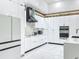 A modern kitchen with white cabinets, marble countertops, stainless steel appliances, and sleek black accents at 704 Forest View Ct, Winter Springs, FL 32708