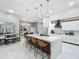 Open concept kitchen with large marble island, bar seating and modern appliances, offering a seamless flow for entertaining and dining at 704 Forest View Ct, Winter Springs, FL 32708