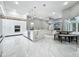 A modern, open-concept kitchen featuring white cabinets, marble countertops, and an adjacent living area at 704 Forest View Ct, Winter Springs, FL 32708