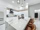 Bright kitchen with white cabinets, marble countertops, stainless steel appliances, and an island with seating at 704 Forest View Ct, Winter Springs, FL 32708