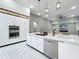 A modern kitchen with white cabinets, marble countertops, stainless steel appliances, and an adjacent living area at 704 Forest View Ct, Winter Springs, FL 32708