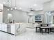 A modern, open-concept kitchen featuring white cabinets, marble countertops, and an adjacent living area at 704 Forest View Ct, Winter Springs, FL 32708