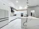An elegant kitchen with white cabinetry, marble countertops, stainless steel appliances, and modern lighting at 704 Forest View Ct, Winter Springs, FL 32708