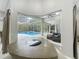 A sunroom with a view of the screened pool, outdoor seating, and modern furniture at 704 Forest View Ct, Winter Springs, FL 32708