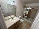 Bathroom with a large mirror, neutral-toned vanity, toilet, and tub with glass doors at 8258 Golden Chickasaw Cir, Orlando, FL 32825