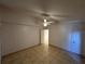 Bright bedroom with tile flooring, a ceiling fan, and a door leading to a hallway at 8258 Golden Chickasaw Cir, Orlando, FL 32825