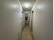 Neutral hallway showcasing tile flooring, leading to multiple rooms with white doors at 8258 Golden Chickasaw Cir, Orlando, FL 32825