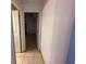 Hallway showcasing tile flooring, leading to rooms with bright, neutral walls and white doors at 8258 Golden Chickasaw Cir, Orlando, FL 32825