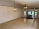 Open-concept living room featuring neutral tile flooring, ceiling fan, and natural light, perfect for entertaining at 8258 Golden Chickasaw Cir, Orlando, FL 32825