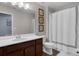 Bathroom with wood cabinets, white counter, and tub-shower combination with curtain at 8968 Hildreth Ave, Orlando, FL 32832