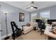 Home office/bedroom with a ceiling fan, neutral walls, two desks, a lounge chair and wood-look flooring at 8968 Hildreth Ave, Orlando, FL 32832