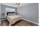Comfortable bedroom with neutral tones, wood floors, and a large window providing plenty of natural light at 8968 Hildreth Ave, Orlando, FL 32832