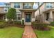Inviting townhome featuring a blue front door, brick pathway, and landscaped yard at 8968 Hildreth Ave, Orlando, FL 32832
