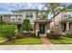 Inviting two-story townhome featuring a well-manicured lawn, beautiful landscaping, and a charming blue front door at 8968 Hildreth Ave, Orlando, FL 32832