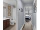 Hallway view into primary suite bath with wood floors and modern framed artwork at 8968 Hildreth Ave, Orlando, FL 32832